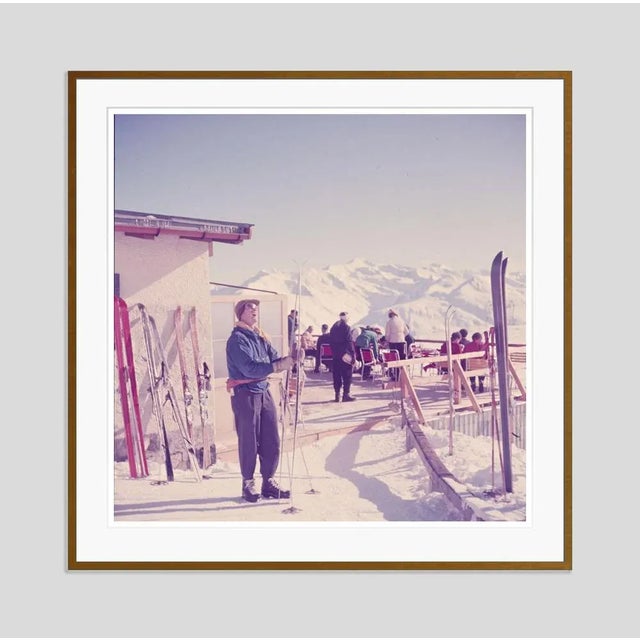 Mountain Top 1951 by Toni Frissell A skier checks their skis at a mountain top terrace, Klosters, Switzerland, 1951....