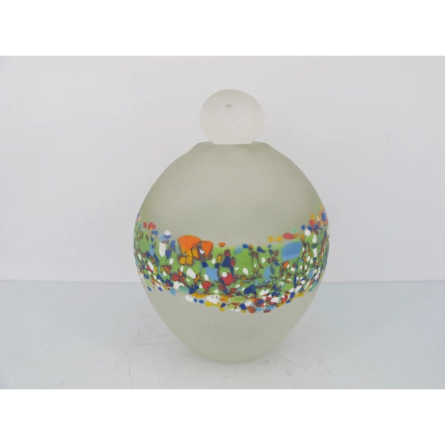 Signed art glass stoppered bottle, Carlin, 90. Multi-colored mosaic band around middle. Bright, bold colors on clear...
