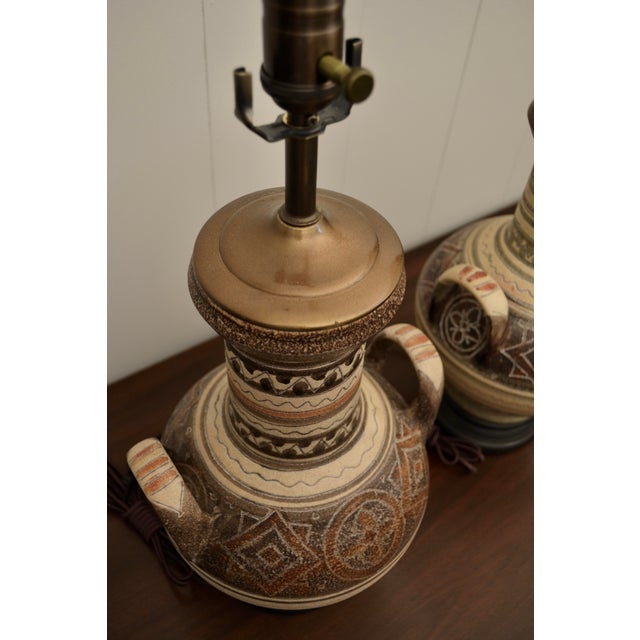 A great pairing of southwest style studio pottery lamps on turned wood bases. Although the lamps share a common urn shape,...