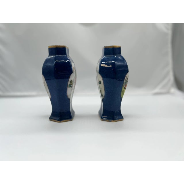 Chinese, likely late Qing Dynasty. A pair of porcelain urn or vases with a rich blue cobalt ground body accented by...