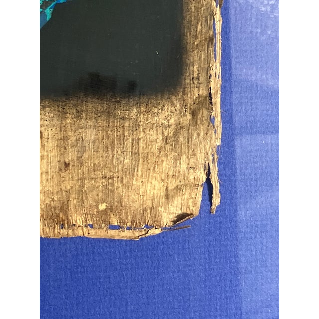 This Egyptian papyrus artwork depicts the mask of an ancient Pharaoh, rendered in bold cobalt blue with luminous...