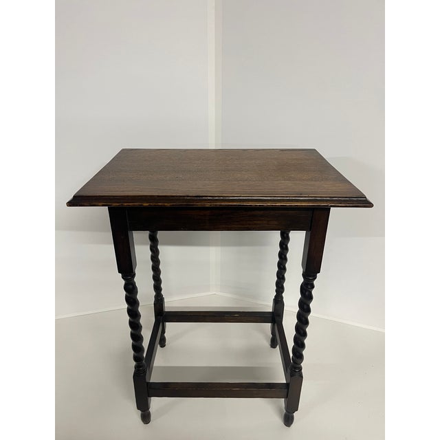 A classically styled small English oak side table in a dark stained finish with visible wood grain, a rectangular top with...