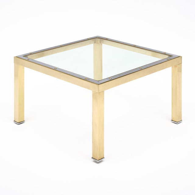 Side table from France in the Modernist style. This piece is made with a brass structure and chrome steel detailing. The...