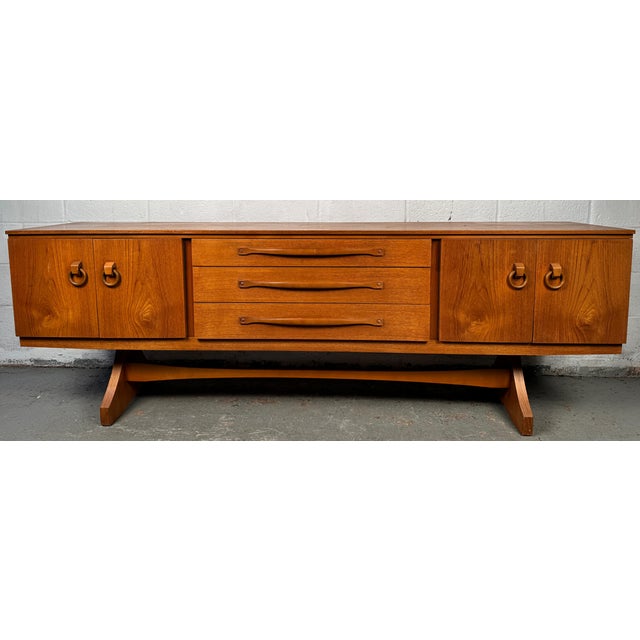 Add timeless sophistication to your home with this stunning vintage teak sideboard, expertly crafted by the renowned...