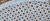 Charming small round tripod side table in perforated and white lacquered wrought iron. The tabletop is perforated with a...