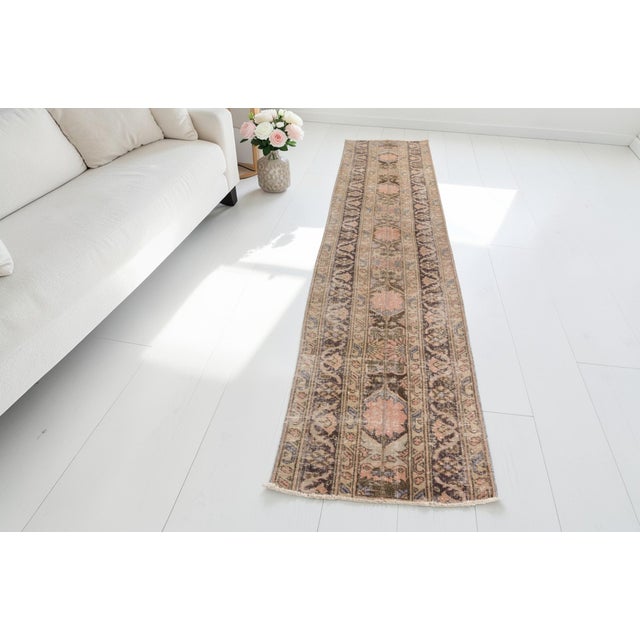 This is a vintage Turkish Oushak rug from the Mid 20th Century. The piece was hand-knotted.