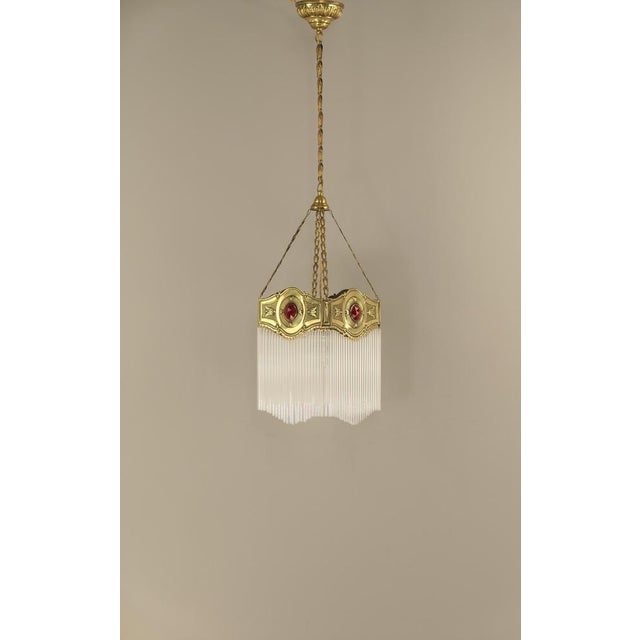 Brass chandelier with cut Pourpour red glass prisms In complete original condition, polished If required, the lamp can be...