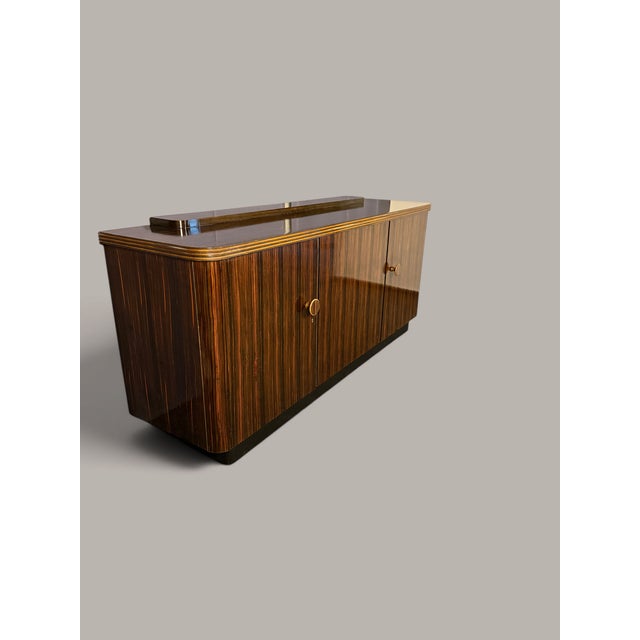 The vibrant grain of the Makassar ebony gives this large sideboard its distinctive character. Dark, warm brown grains...