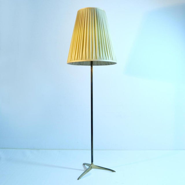 Elegant Kalmar floor lamp, Vienna circa 1950's has an aerodynamic cast brass tripod foot, patinated brass stem and large...