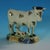 Staffordshire Yorkshire Pottery Prattware figure which features a cow with a recumbent calf, stood on a rectangular base,...