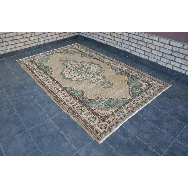 This is a vintage Turkish Oushak rug from the 1960s. The piece was hand-knotted.