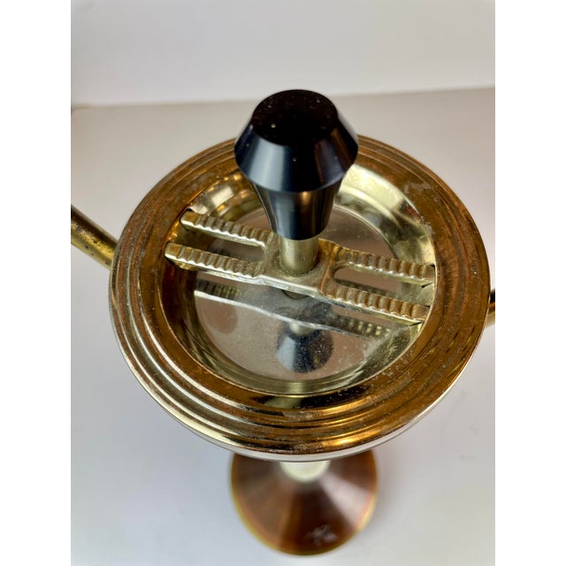 Clean and functional Culbuto ashtray with handle, made of brass and copper, designed in Italy in the late 1950s or early...