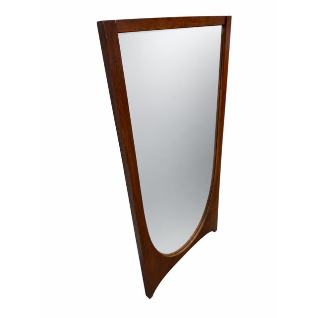 A striking Mid-Century Modern Broyhill Brasilia sculpted walnut mirror, celebrated for its bold architectural form and...