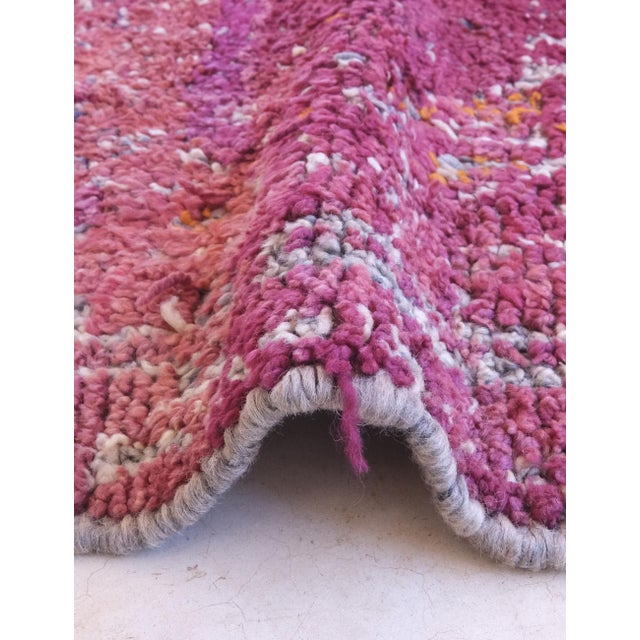 This handwoven Berber wool carpet from the Middle Atlas Mountains embodies a rich cultural heritage through its vibrant...