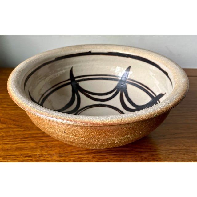 This wonderful handmade studio art pottery large bowl features geometric motifs on a natural ground and Brown glazed...