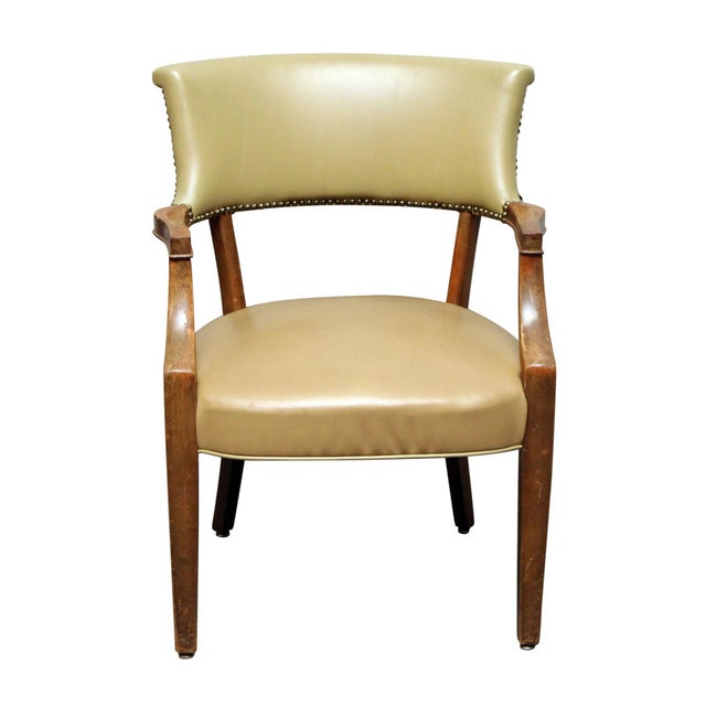 Tan upholstered leather chair with studs and a wood frame. In great condition. The manufacturer and exact date of creation...