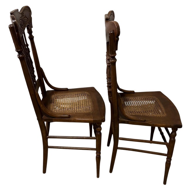A Pair of Antique Oak Pressed Back Chairs with Cane Seats .