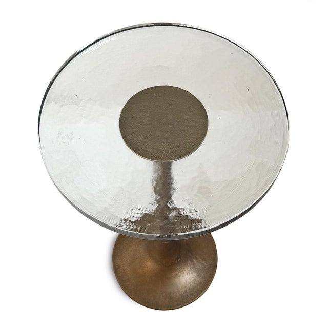 Sophisticated side table featuring a substantial thick glass top paired with a sculptural cast aluminum pedestal base...