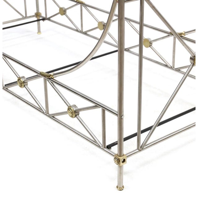 Elegant neoclassical bed frame executed in brushed steel with applied brass detailing, reflecting the refined...