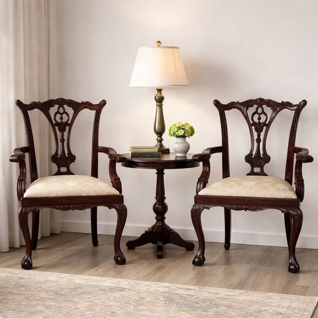 A handsome pair of late 20th century Chippendale-style mahogany armchairs featuring finely carved pierced splats,...
