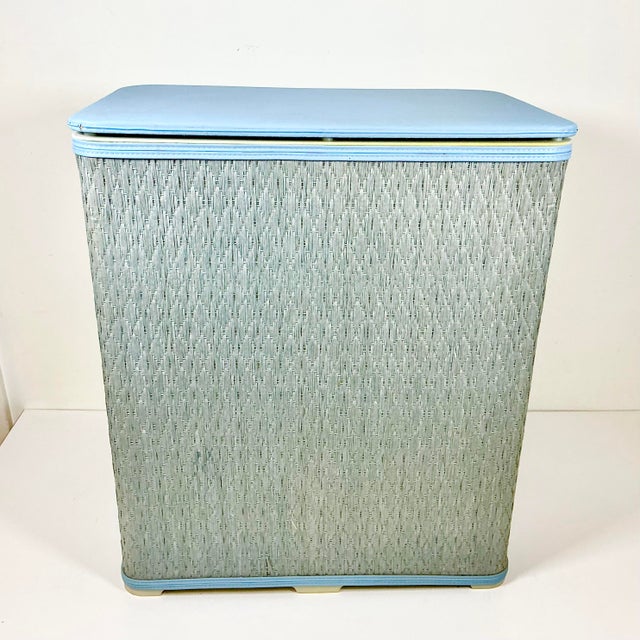 This Mid-Century Raffia woven Hamper is in fine shape. It features a French Blue dyed Raffia body, a vinyl padded hinged...