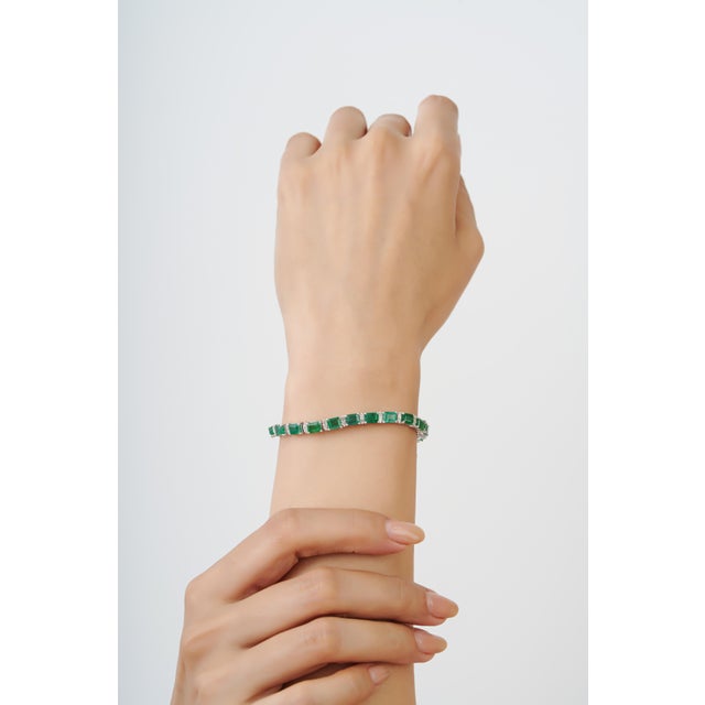 This Regal 12 Ct Emerald & Diamond Line Tennis Bracelet features 12 carats of natural octagon-cut emeralds, arranged in a...