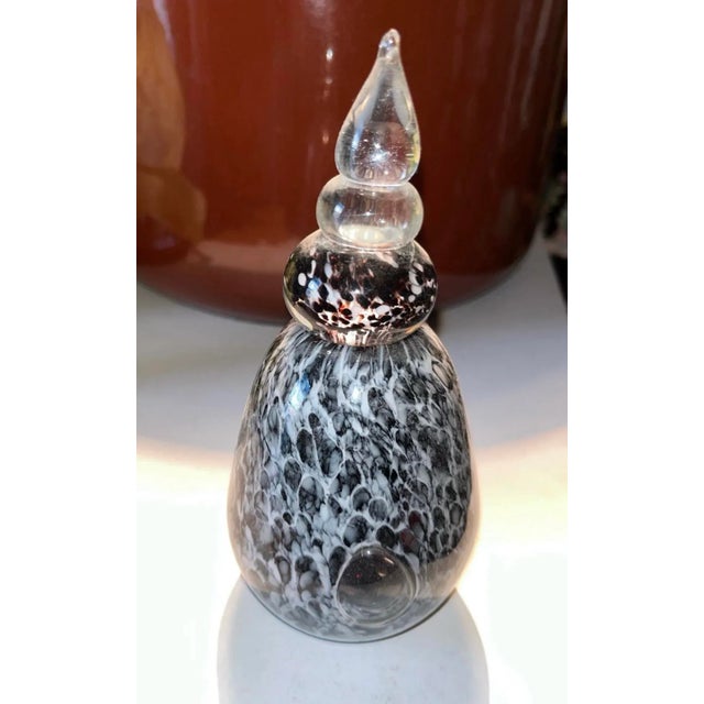 Brownish black and white art glass bottle with swirl stem and bottom bubble with top 2 clear glass top. 7" tall total 4"...
