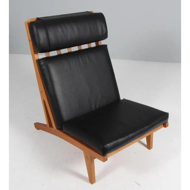 Hans j. Wegner lounge chair with loose cushions new upholstered with black pure full grain aniline leather. Frame of oak....