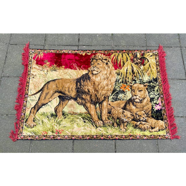Decorative wall tapestry or rug in woven velvet. It depicts a lion family in a jungle setting. It was made during the...