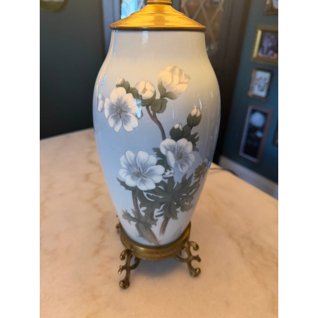 Bing & Grøndahl, Copenhagen, porcelain vase lamp, hand-painted white flowers on a pale blue ground. Brass footed base,...