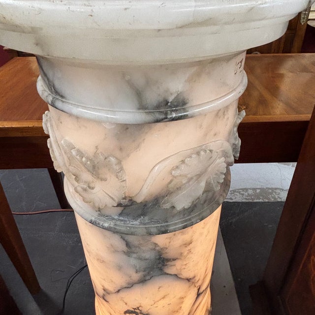 Antique Liberty-era alabaster column from the 1920s electrified with a lamp. Relief work with leaves and grapes....