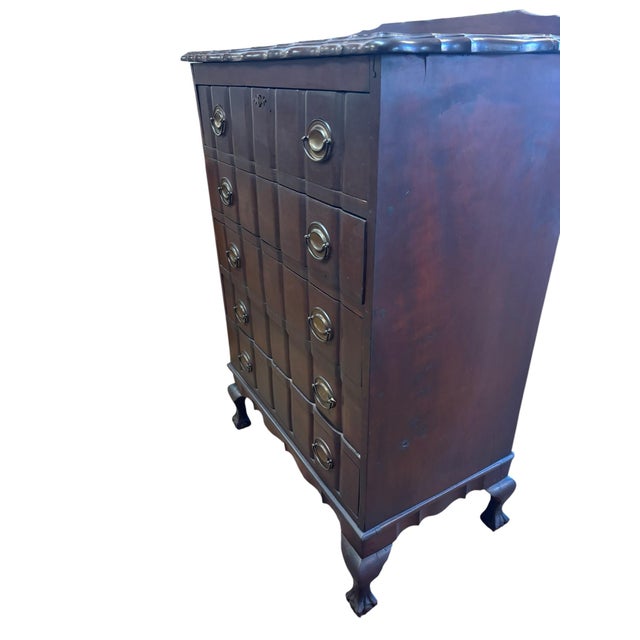 A handsome vintage Chippendale-style mahogany tall chest featuring five drawers with paneled fronts, brass bail pulls,...