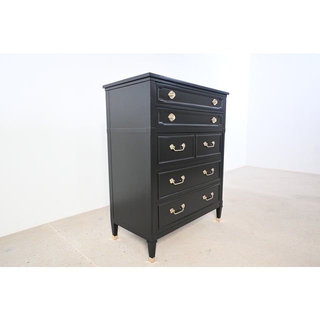 This French Louis XVI style highboy by Drexel features a striking black lacquered finish complemented by refined brass...