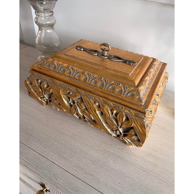 A bold, elegant oversized decorative ceramic box featuring beautiful, raised gilt floral relief detailing. This...