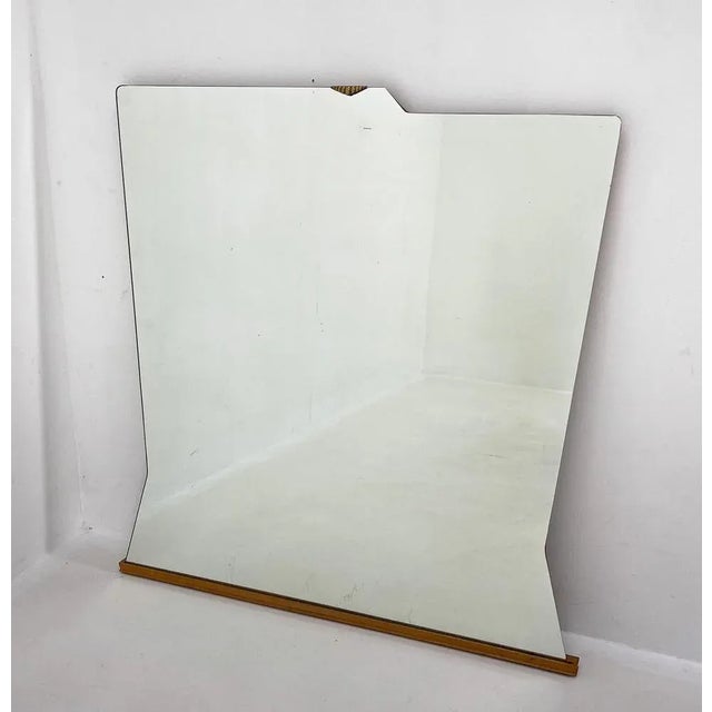 Large, asymetrical wall mirror mounted on wood with brass detail by Santambrogio & de Berti. Produced in Italy. This piece...