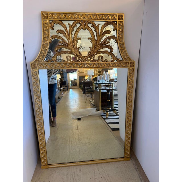 Striking large and unusually shaped giltwood mirror having sculpted ornate top that curves in on each side.