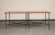 Midcentury bronze two-piece dining table on casters with red lacquer top and brass accents. Two squares join to form a...