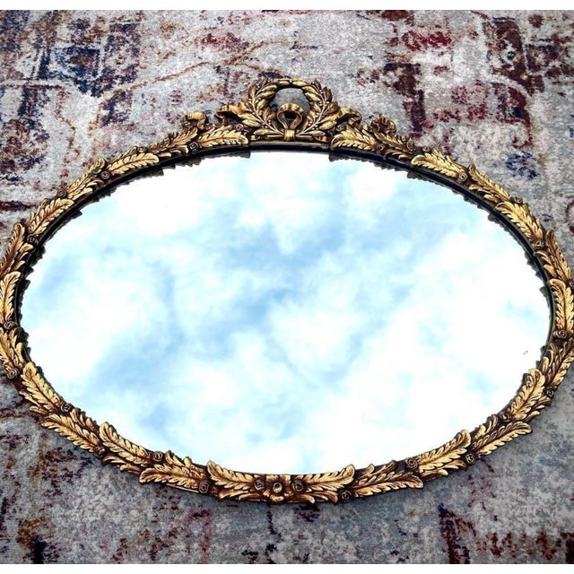 Absolutely stunning antique oval wall mirror, featuring a Laurel Wreath design with small rosettes. A laurel wreath is...