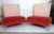 Mid-century style lounge chairs featuring a uniquely designed backrest, large red comfortable seat, on a set of sturdy...