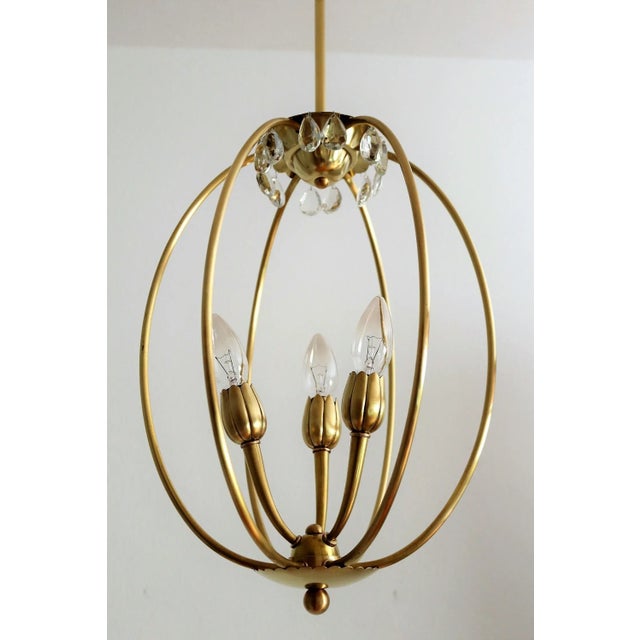Very particular pendant lamp made of full brass bars and brass details. Extreme minimal design. Under the top plate are...
