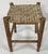 Antique square turned wood stool with woven rattan top. Nice detail to legs. Measures 15"H. Age wear. Sturdy.