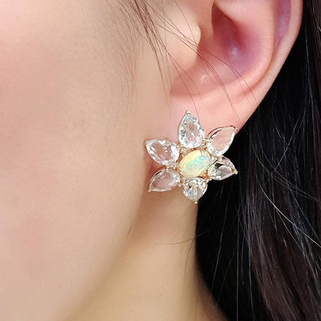 A striking pair of opal and prasiolite earrings crafted in 14ct yellow gold. Each centre opal shows vivid iridescence,...