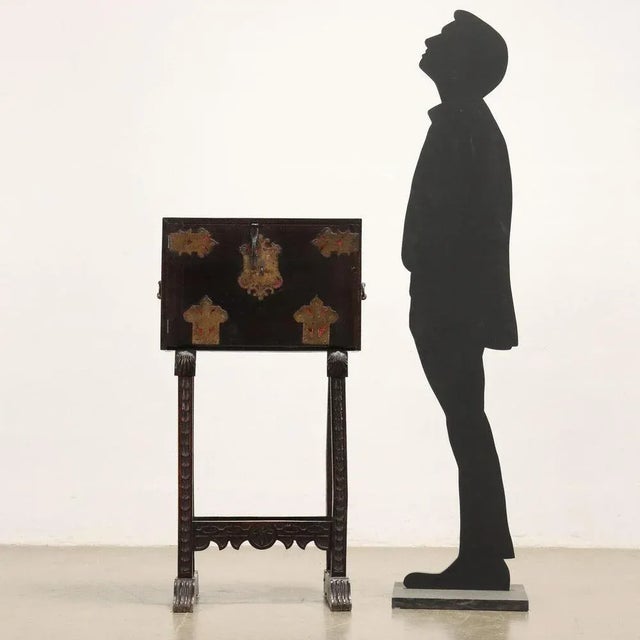 Ebonized wood style cabinet with decorated door front with central ornamental lock, gilt sheet metal with red ground and...