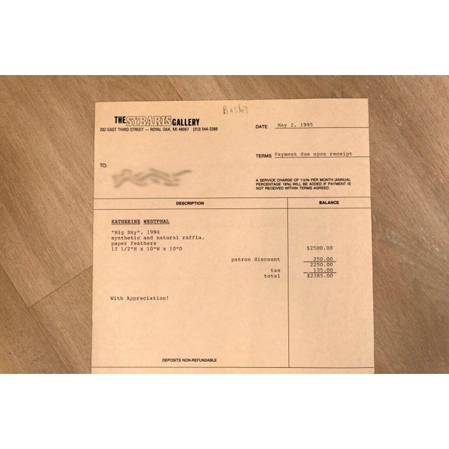 "Big Sky" is a striking raffia woven basket with feather accents, skillfully crafted by the acclaimed artist Katherine...