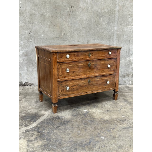Elegant 19th century Italian neoclassical commode crafted from richly grained walnut and featuring refined inlaid...