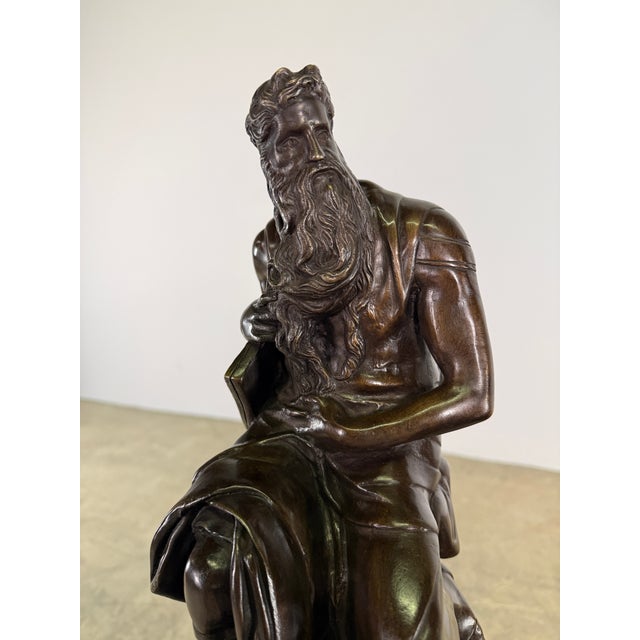 Hand cast bronze sculpture depicting a seated, bearded Moses, rendered in the tradition of classical and Renaissance...