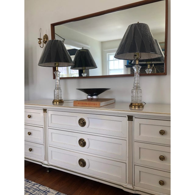 Modern twist on classic lamps. Cut crystal/glass atop a polished brass base creates visual interest. 20” to top of socket.