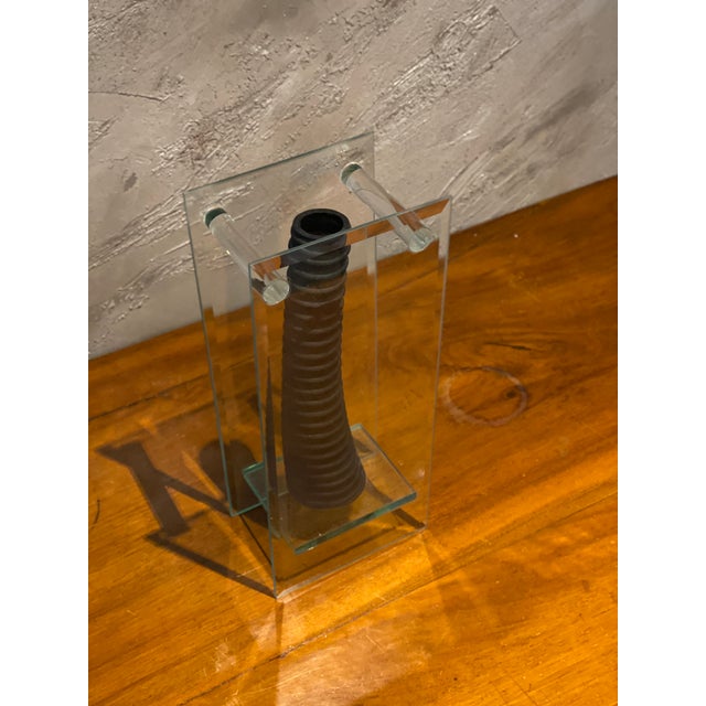 An original sculptural vase featuring an architectural structure in clear cut glass enclosing a central element in black...