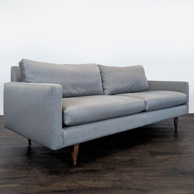 This Room & Board 3-seat sofa features a clean, modern design with a light gray fabric and sturdy wooden legs. Its...