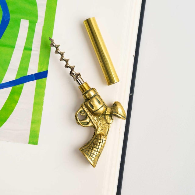 A clever vintage corkscrew bottle opener cast in brass in the shape of a revolver. The barrel unscrews to reveal a hidden...